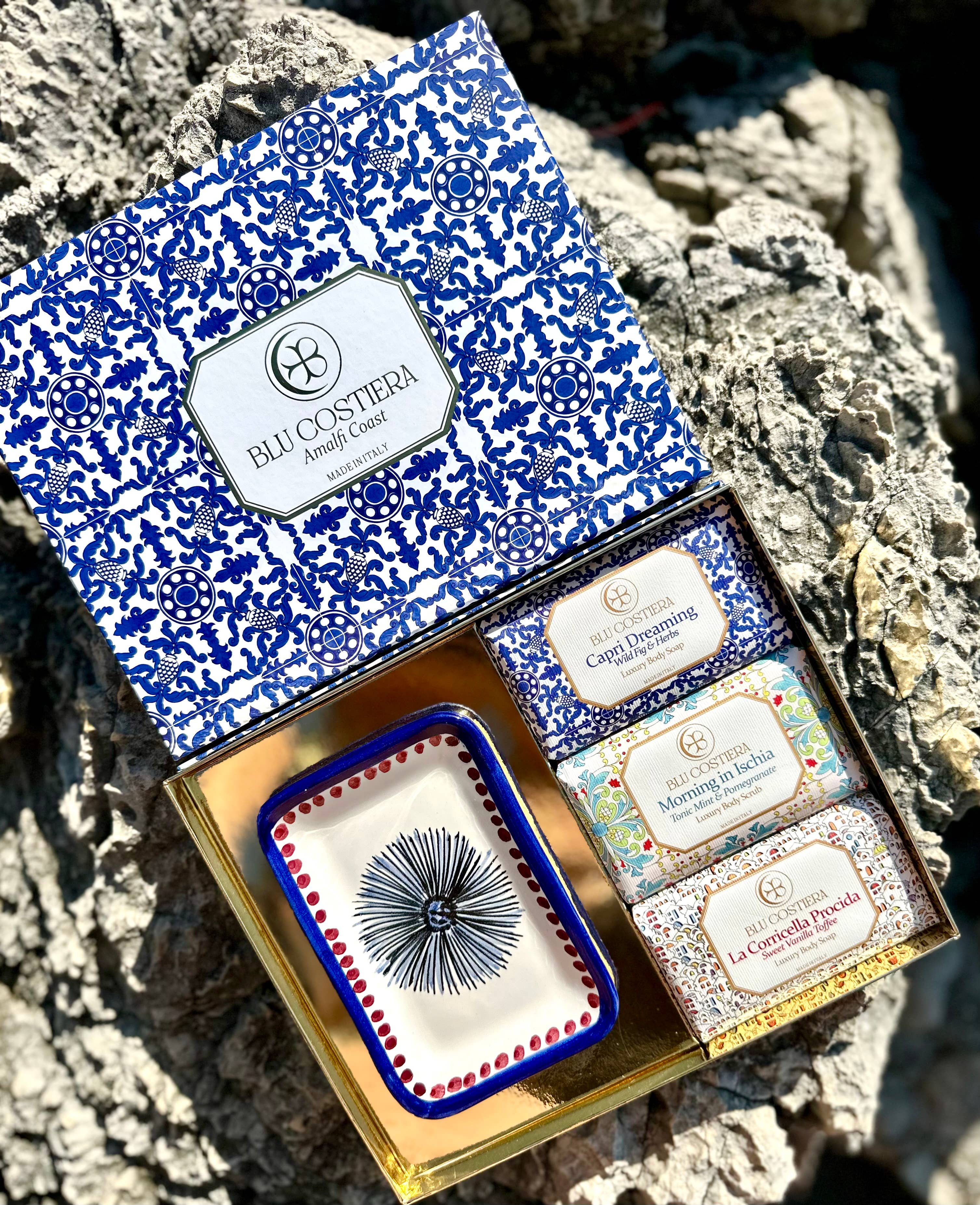 Geschenkbox Blu Costiera Amalfi Coast – geöffnete blaue Majolika-Box mit Vietri-Keramikschale und drei Seifen, auf Stein
