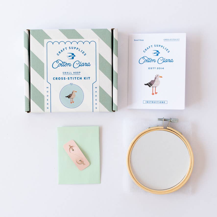 Cotton Clara Cross-Stitch Kit Seemöwe – gestreifte Verpackungsschachtel und Stickrahmen