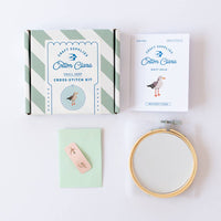 Cotton Clara Cross-Stitch Kit Seemöwe – gestreifte Verpackungsschachtel und Stickrahmen