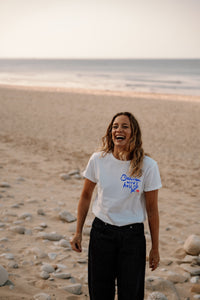 Frauen T-Shirt „Dahinten wird's hell" – weiß, Aufdruck in Blau, getragen am Strand | Ankerherz
